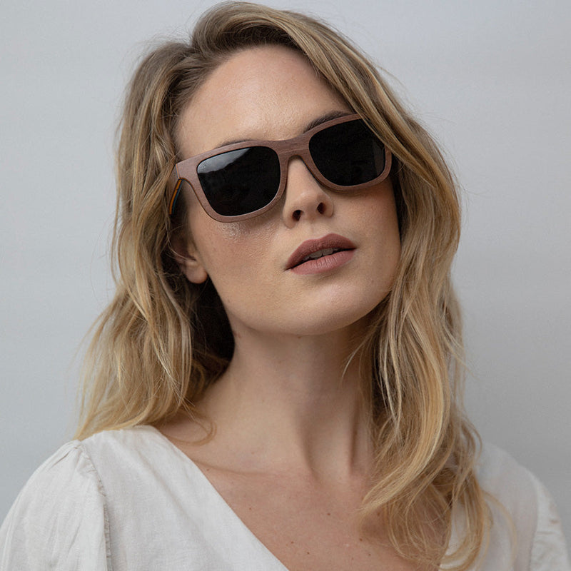 Woman wearing eco-friendly wooden sunglasses with charcoal lenses