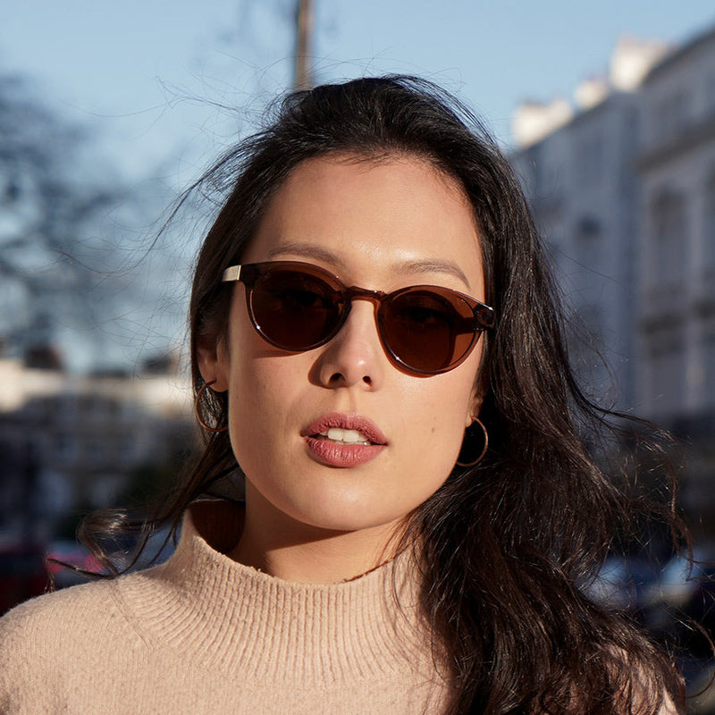 Gril wearing transparent brown acetate sunglasses with amber lenses