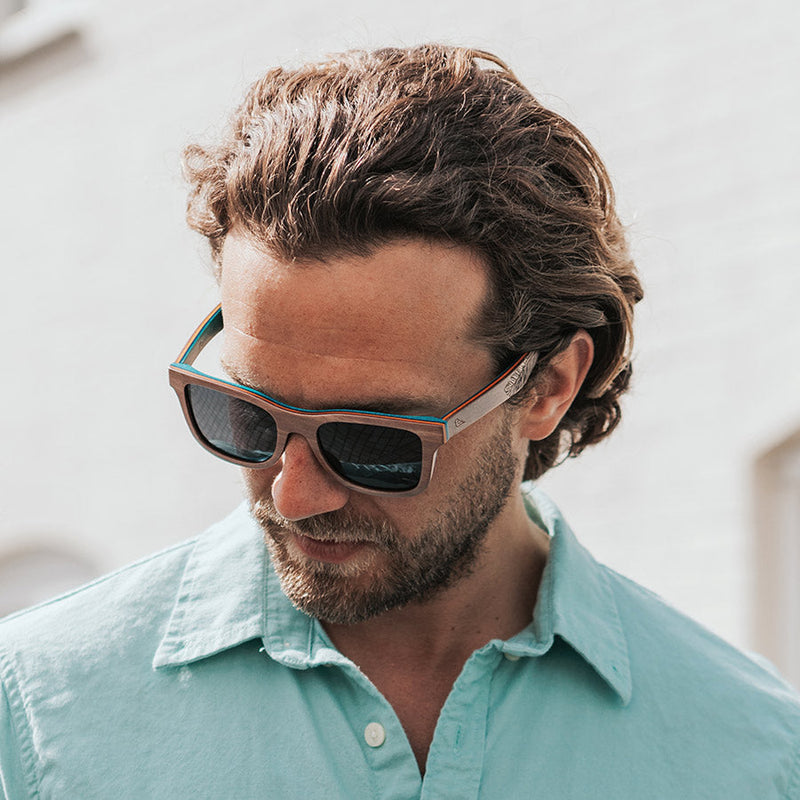 Man looking down wearing eco-friendly wooden sunglasses with blue wood inside