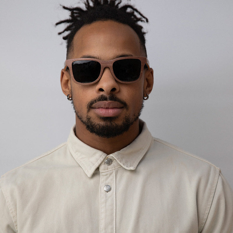 Black man wearing eco-friendly wooden sunglasses with charcoal lenses