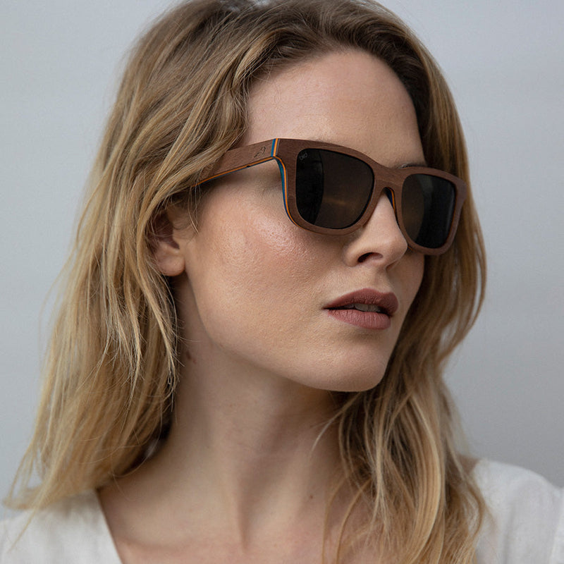 Woman looking sideways wearing eco-friendly wooden sunglasses with charcoal lenses