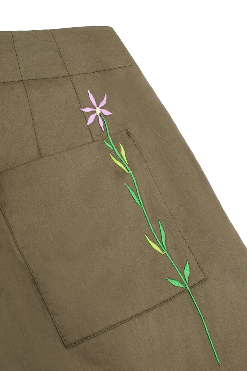 Product detail shot of Saywood's Amelia wide leg trousers in khaki, back close up of patch pocket and lilac embroidered flower