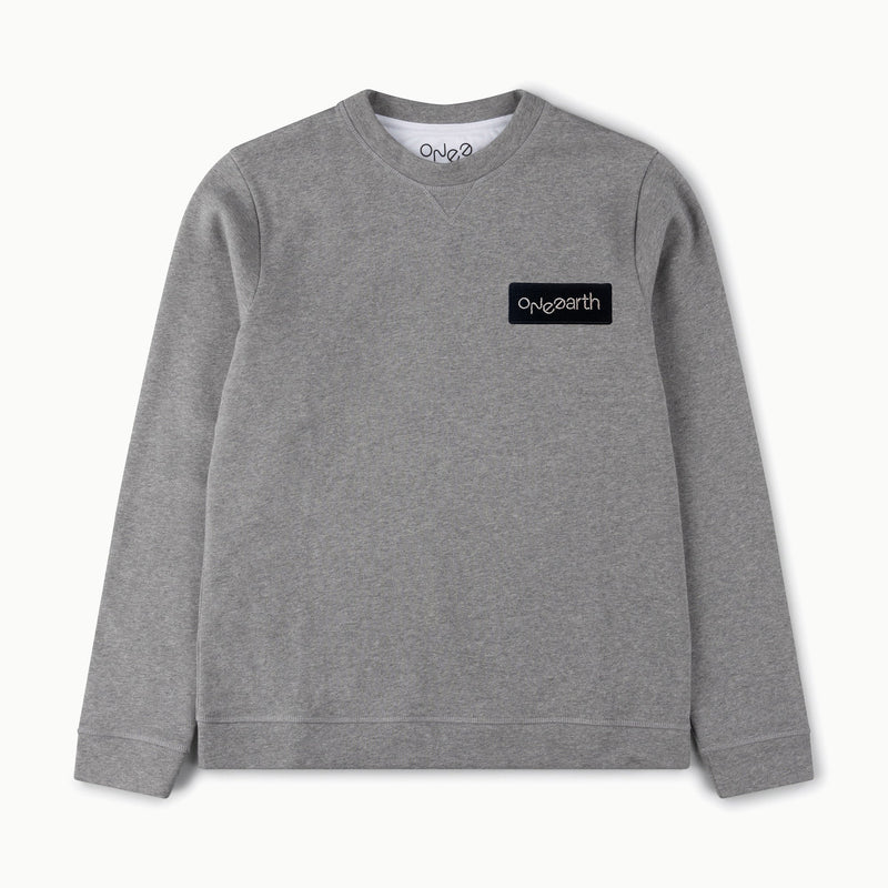 ONE Earth logo embroidered patch sewn onto grey marl organic cotton sweatshirt on left hand side of chest as worn