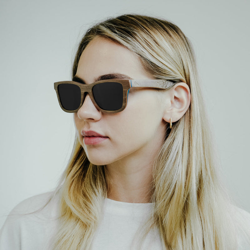 Blonde girl wearing eco-friendly wooden sunglasses with black lenses